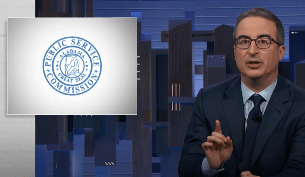 John Oliver discusses utility scandals next to a title card displaying the logo of the Alabama Public Service Commission.